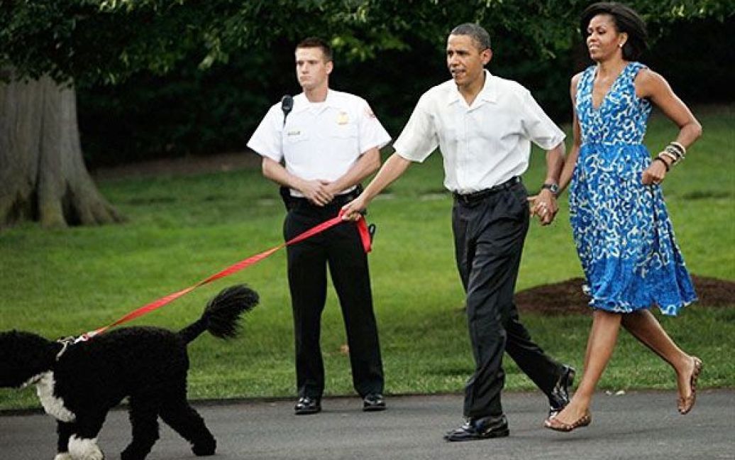 США, Вашингтон. Президент США Барак Обама і перша леді Мішель Обама під час прогулянки із собакою перед пікніком Конгресу, який відбувся на Південній галявині Білого дому у Вашингтоні. / © AFP