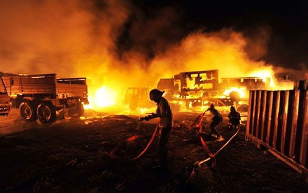 Пакистан, Ісламабад. Пакистанські пожежні намагаються загасити палаючі вантажівки НАТО, на яких перевозять військовий транспорт та нафту, після нападу бойовиків. Озброєні бойовики напали на станцію поблизу Ісламабада і підпалили десятки вантажівок з військовою технікою і нафтою, які здійснювали постачання палива для військ НАТО у Афганістані / © AFP