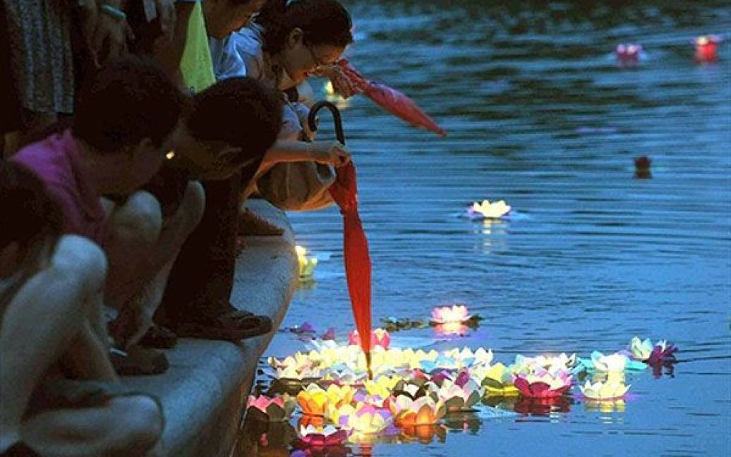 Китай, Пекін. Китайські сім&#039;ї збираються на березі озера при свічках, щоб пустити на воду квіти лотоса і побажати щастя під час свята Дуанву, відомого також як свято човнів-драконів. У Китаї свято Дуанву було відновлено, як офіційне державне свято, тільки у 2008 році. Традиційно це свято відзначають у багатьох китайських громадах Східної Азії і Південно-Східної Азії. / © AFP