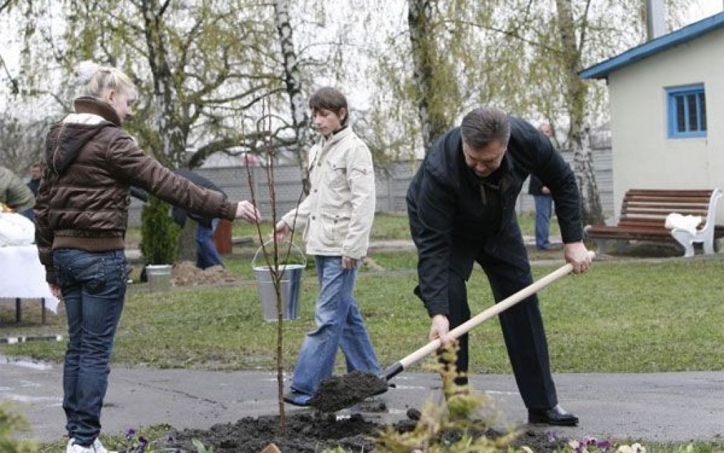 Віктор Янукович разом з двома вихованцями посадив молоду яблуню. / © President.gov.ua