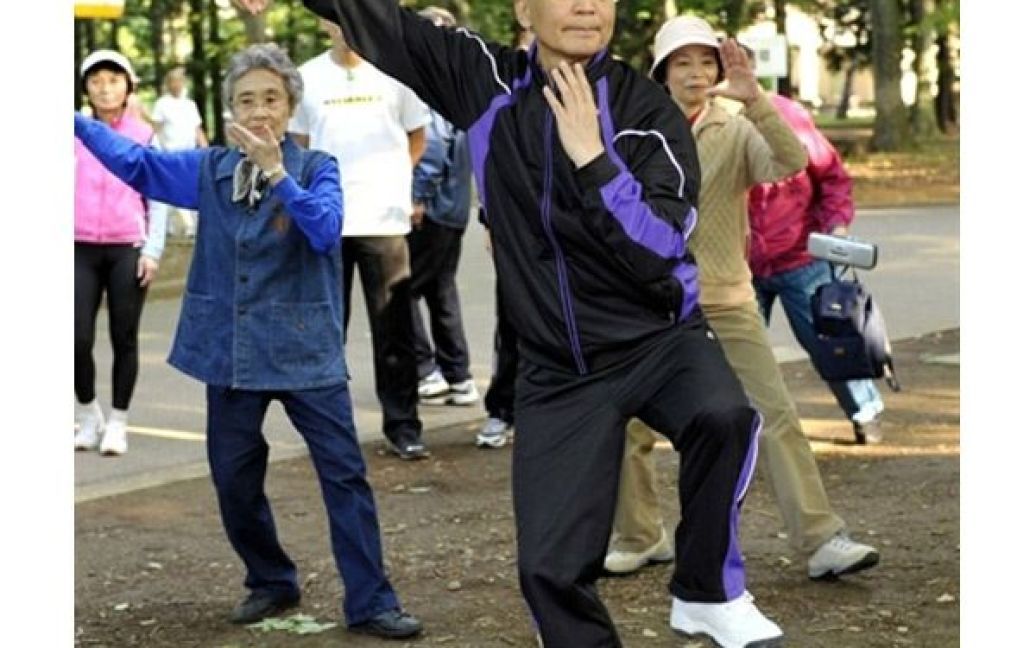Японія, Токіо. Китайський прем&#039;єр Вень Цзябао разом із місцевими мешканцями виконує ранкові вправи гімнастики Тай Чі у міському парку. У Токіо відбулись переговори на вищому рівні між Південною Кореєю, Китаєм і Японією. / © AFP