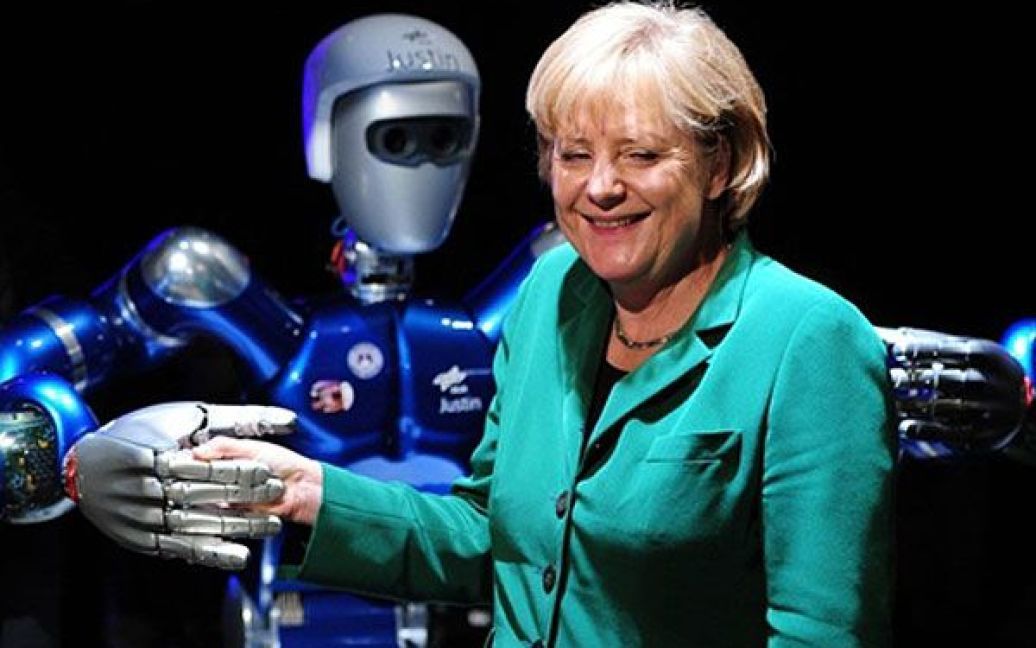 Німеччина, Берлін. Федеральний канцлер Німеччини Ангела Меркель жартує з гуманоїд ним роботом "SpaceJustin" на міжнародному аерокосмічному салоні, який стартував в аеропорту Шенефельд. Міжнародний авіасалон ILA-2010 є третьою за величиною в Європі авіавиставкою, після "Фарнборо" (Англія) та "Ле Бурже" (Франція). Очікується, що цього року у авіасалоні візьмуть участь більше 1100 експонентів з 37 країн. / © AFP