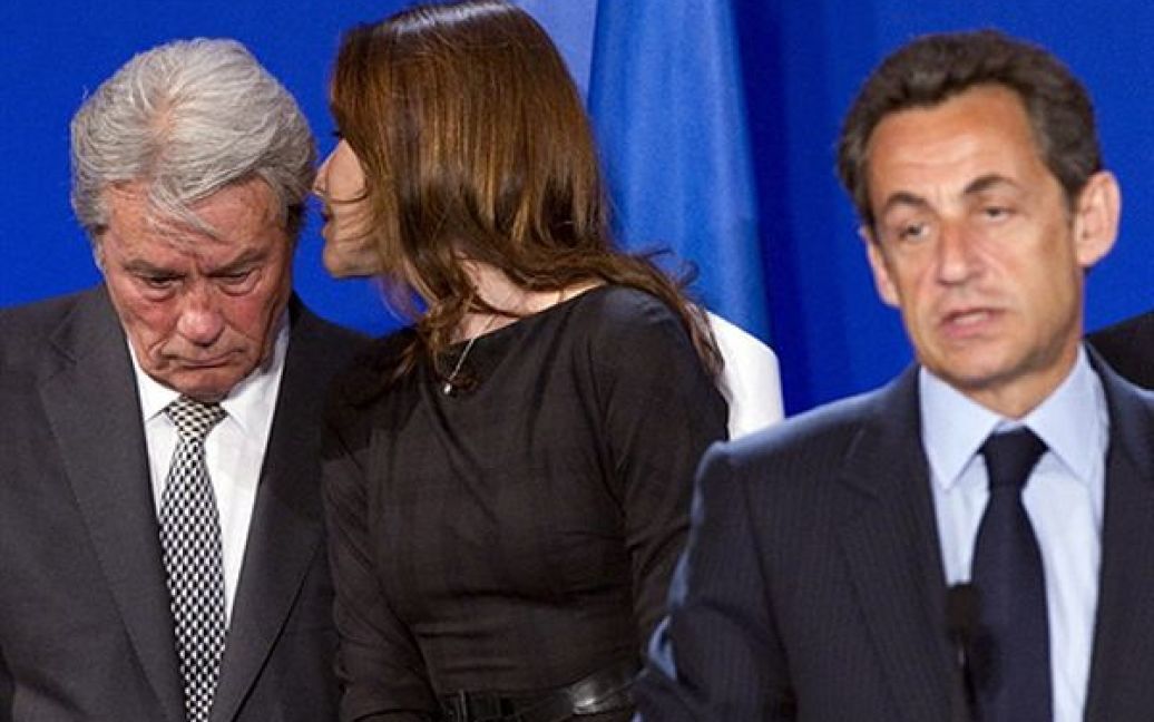 Перша леді Франції Карлі Бруні-Саркозі перешіптується з актором Аленом Делоном під час промови Ніколя Саркозі на урочистому відкритті Французького павільйону Всесвітньої виставки у Шанхаї. / © AFP
