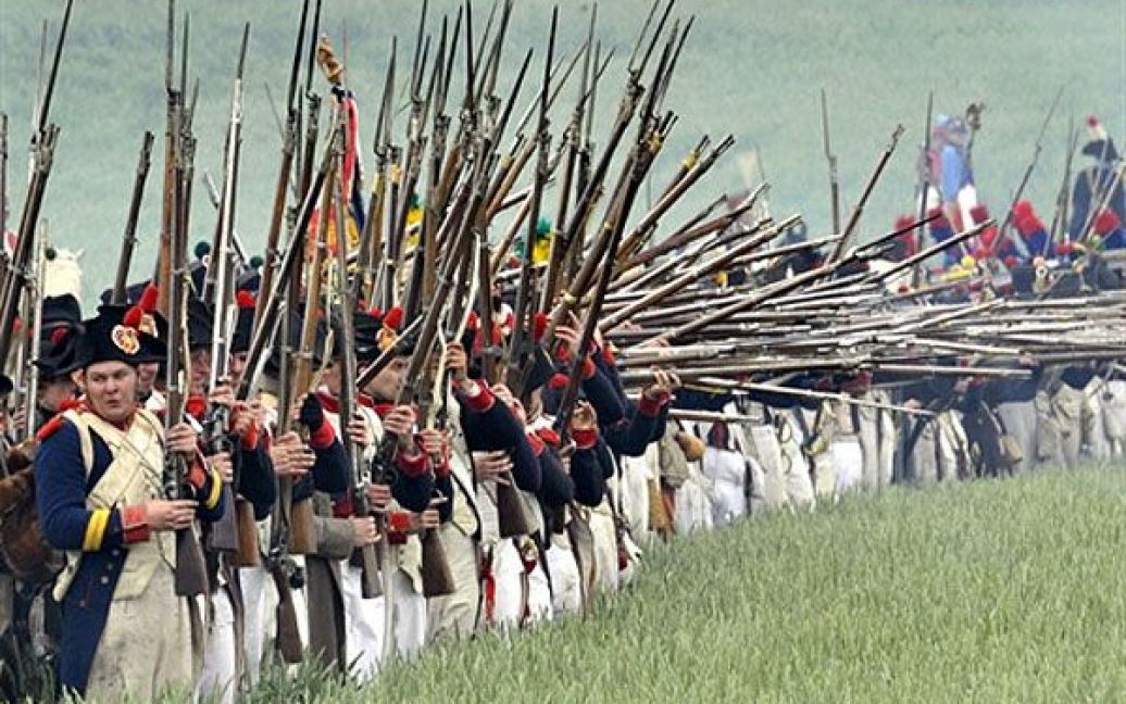Бельгія, Ватерлоо. Чоловіки, одягнені у давню військову форму, під час реконструкції битви при Ватерлоо 1815 року. Битва при Ватерлоо між французькою армією на чолі з Наполеоном і союзними військами під керівництвом герцога Веллінгтона і фельдмаршала Блюхера відбулась 18 червня 1815 року. Наполеон повів 72-тисячну армію у бій із 120 тисячами англійських і прусських солдатів. Довгий час тривала кривава битва, але наприкінці дня Велика французька армія імператора Наполеона була розгромлена герцогом Веллінгтоном і фельдмаршалом Блюхером. / © AFP