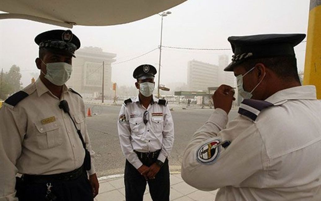 Ірак, Багдад. Іракські поліцейські у захисних масках регулюють рух на центральній площі Багдада. Столиця Іраку вкрита шаром густого пилу через сезонні піщані бурі. / © AFP