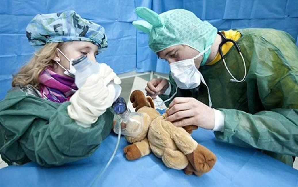 Німеччина, Берлін. Дитина та студент-медик проводять "операцію" на ляльці у так званій "Лікарні Teddy Bear". "Лікарню Teddy Bear" організували студенти для дітей дошкільного віку, з метою зменшити їхній страх перед лікарями та лікарнями. / © AFP
