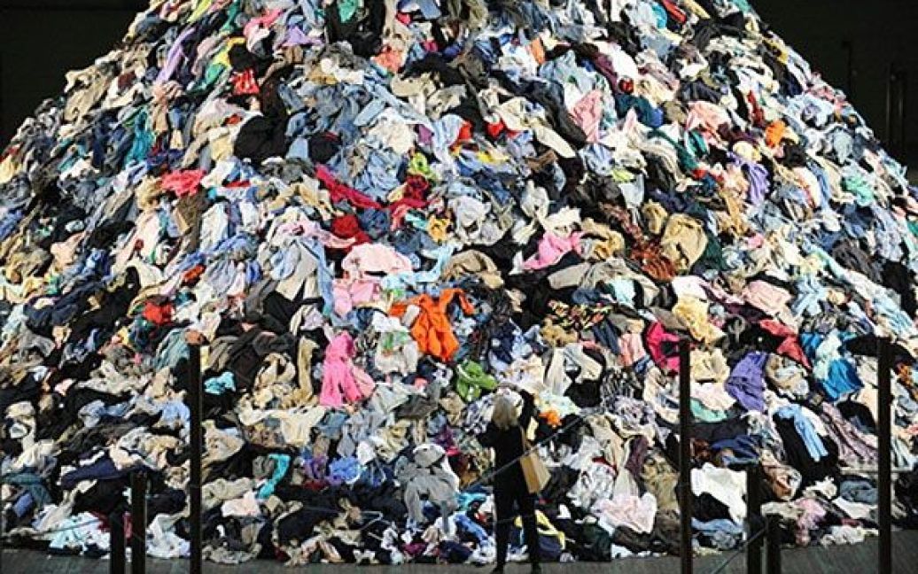 США, Нью-Йорк. На виставці жінка фотографує роботу французького художника Крістіана Болтанські "Нічийна земля", що складається з 27,2 тонн поношеного одягу. / © AFP