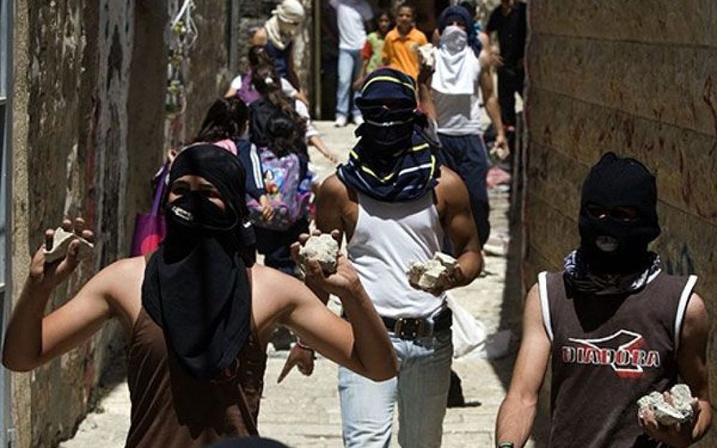 Палестинська молодь з камінням в руках збирається на акцію протесту в Єрусалимі. / © AFP