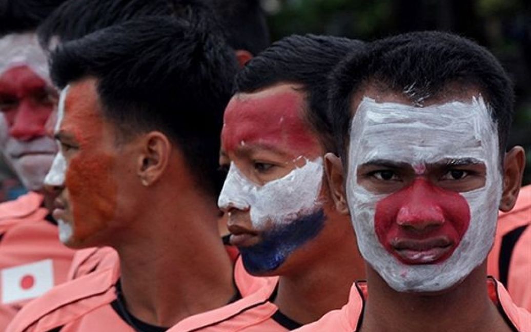 В&rsquo;язні бангкокської тюрми, які розфарбували свої обличчя у кольори країн, що беруть участь у ЧС-2010, чекають свого виходу на поле під час тюремного футбольного турніру. / © AFP