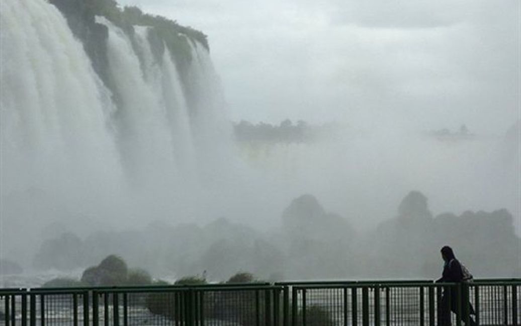 Бразилія. Туристи гуляють біля водоспаду Ігуасу. Вода у системі водоспадів, яка розташована на кордоні Бразилії та Аргентини, падає з висоти 2,4 кілометрів. Цікаво, що під час надзвичайно сильних засух водоспад повністю пересихає. / © AFP