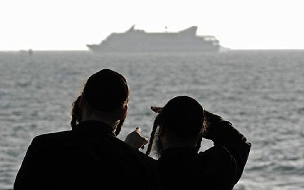 Ізраїль, Ашдод. Два ультра-ортодоксальні євреї дивляться на турецький корабель "Mavi Marmara", який стоїть біля узбережжя південного ізраїльського міста Ашдод. До берегів сектора Газа йде судно MV Rachel Corrie з вантажем гуманітарної допомоги, зафрахтоване пропалестинською правозахисною організацією. ВМС Ізраїлю заявили, що корабель буде перехоплено, як тільки він увійде в територіальні води сектора Газа. / © AFP