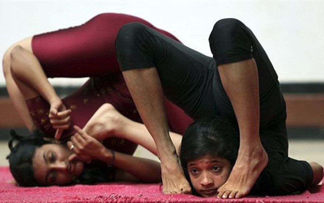 Індія, Бангалор. Індійські студенти коледжу йоги демонструють свою майстерність під час виступів у Бангалорі. Показові виступи були проведені з метою сприяння зайняттям йогою, щоб люди більше дізнались про здоровий спосіб життя завдяки практикуванню йоги тощо. / © 