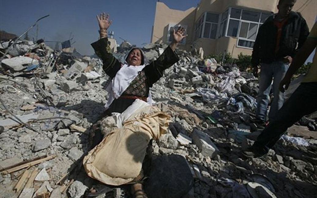 Мати Алі Світі, одного з лідерів ХАМАС, плаче на руїнах його будинку. Сьогодні вночі ізраїльський спецназ оточив будинок Світі та вимагав здатися. Світі відкрив вогонь по солдатам ізраїльської армії. В ході перестрілки його було убито, а будинок зруйновано. / © AFP