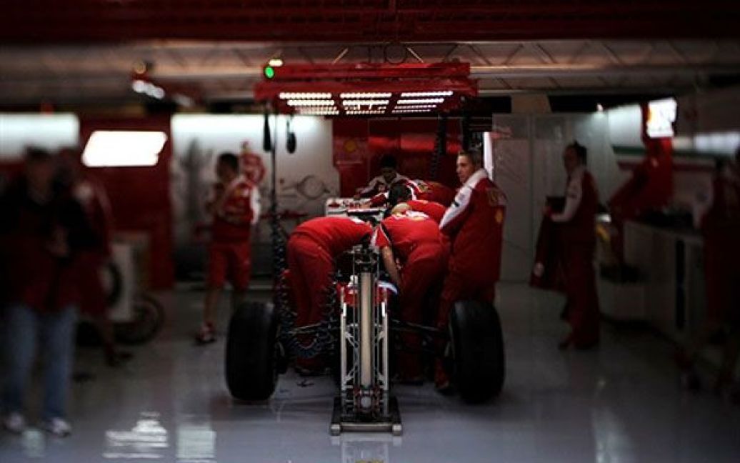 Іспанія, Монтмело. Механіки Ferrari працюють над автомобілем під час піт-стопу на автодромі Каталунья, де за три дні має відбутися іспанське Гран-прі Формули 1. / © AFP