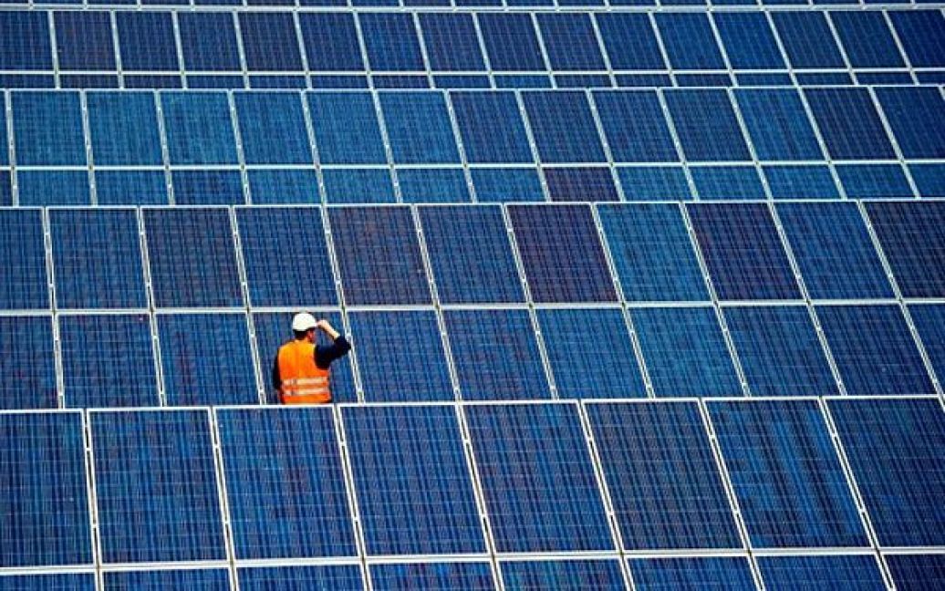 Німеччина. Співробітник стоїть серед панелей сонячних батарей заводу сонячної енергії "FinowTower" у місті Фінофурт. Компанія Solarhybrid AG побудувала величезну сонячну електростанцію на колишньому військовому аеродромі Еберсвальде-Фіноу, офіційне відкриття якої відбулось 15 червня 2010 року. Сонячна електростанція номінальною потужністю 24,5 МВт зможе забезпечити електроенергією 6500 господарств. / © AFP