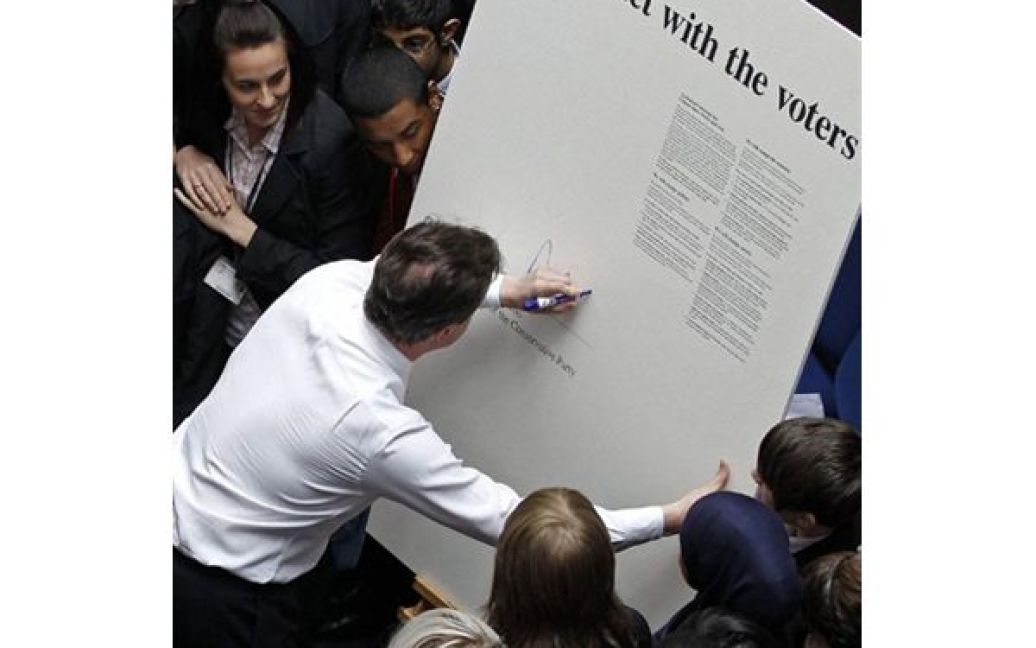 Лідер Консервативної партії Британії Девід Кемерон підписує символічний "Контракт з виборцями" під час свого агітаційного мітингу у Дербі. / © AFP