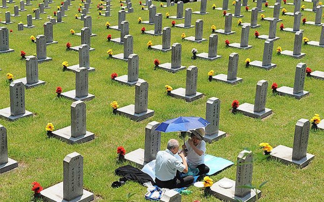 Республіка Корея, Сеул. 81-річний Джу Хонг-Янг та його дружина прийшли на національне кладовище у Сеулі, щоб прибрати на могилах своїх батьків, які загинули під час Корейської війни 1950-1953 рр. У країні відзначили 60-річчя з початку Корейської війни. / © 
