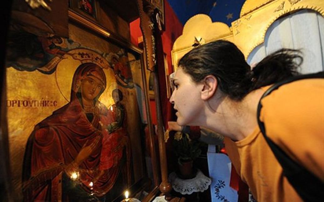 Жінка розглядає сльози на ікони Діви Марії, які з’явилися кілька днів тому, у православній церкві Мілана. / © AFP