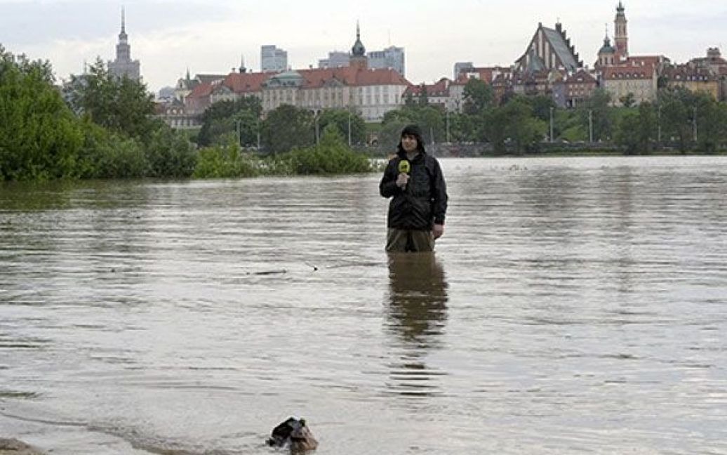 Журналіст працюєє, стоячи у воді на правому березі річки Вісли у Варшаві. / © AFP