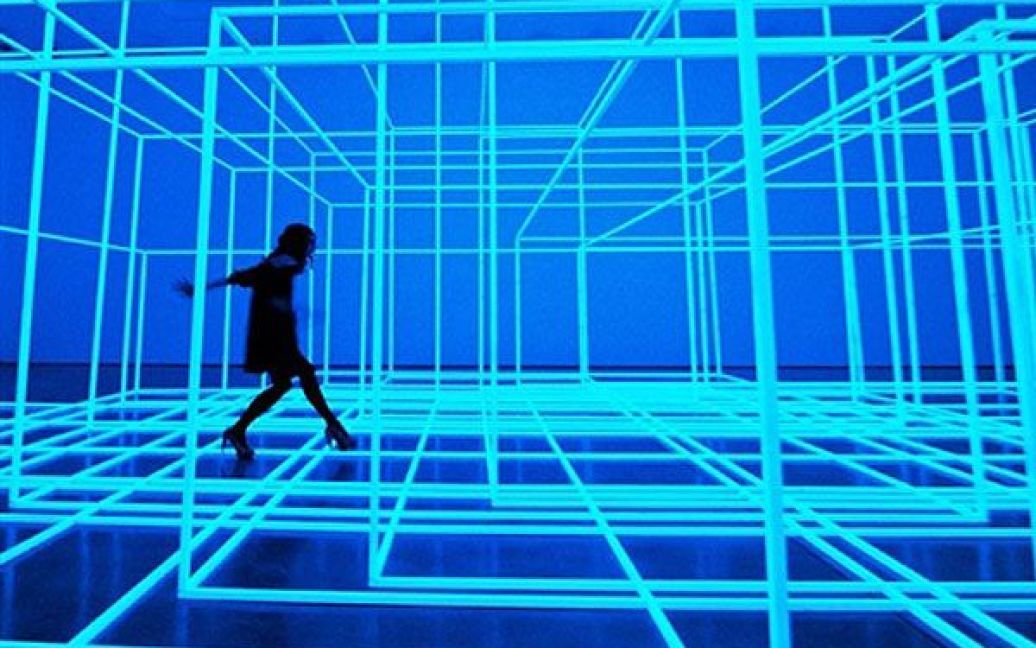Великобританія, Лондон. Жінка пробирається крізь світлову інсталяцію британського художника Ентоні Гормлі "Кімната, що дихає III" перед початком його нової виставки  "Полігони" у галереї "White Cube" у Лондоні. Виставка працюватиме у Лондоні до 4 липня. / © AFP
