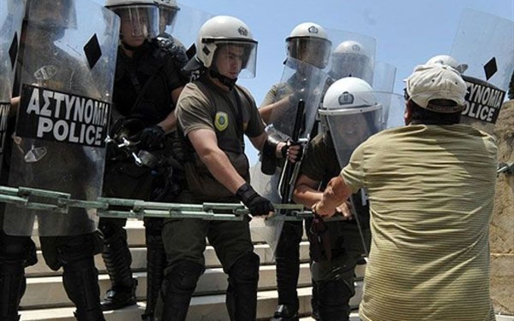 Демонстрант намагається прорватись крізь поліцейський кордон до будівлі парламенту / © AFP