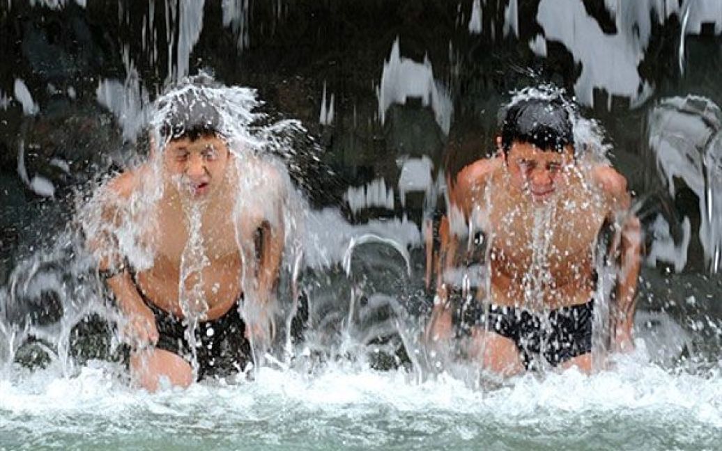 Грузія, Тбілісі. Грузинські хлопчики стоять у фонтані у центрі Тбілісі, щоб трохи охолонути. Температура у місті досягла 36 градусів за Цельсієм. / © AFP