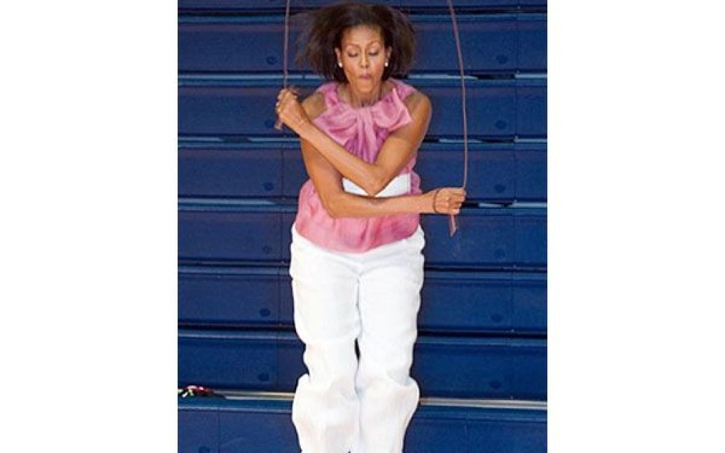 США, Вашингтон. Перша леді США Мішель Обама стрибає через мотузку під час візиту до освітнього табору "Columbia Heights", де вона зустрілась зі студентськими лідерами. У Вашингтоні почала працювати президентська рада з питань фітнесу, спорту і здорового харчування. / © AFP