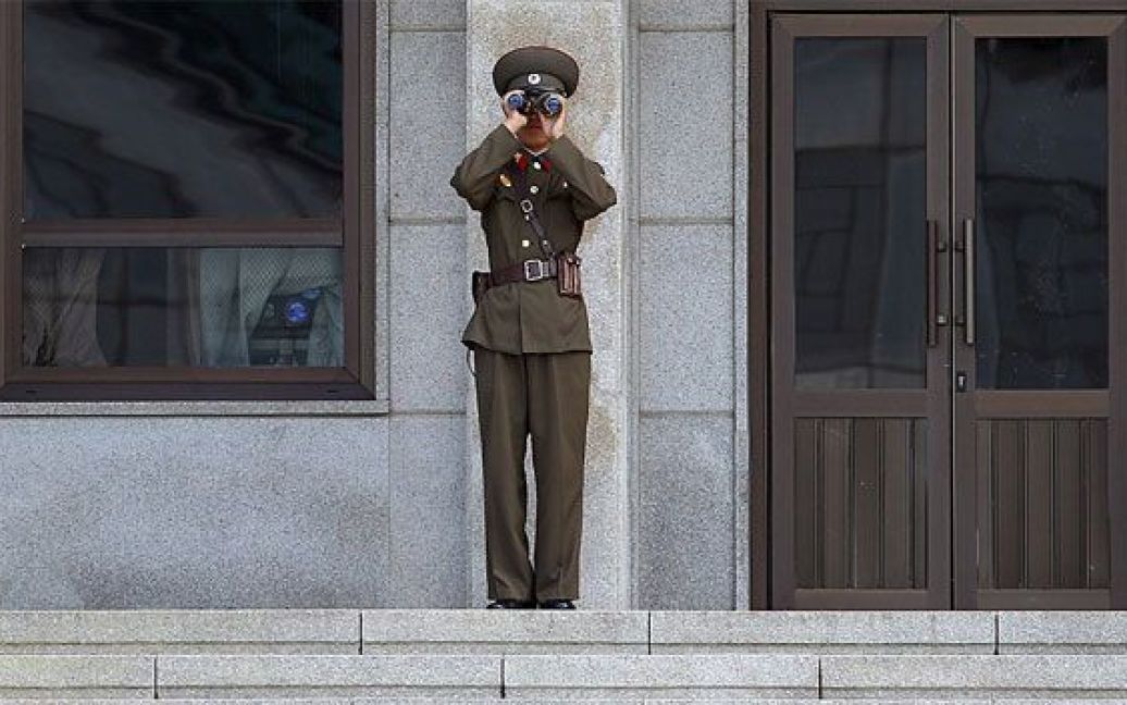 Північна Корея, Пан Мун Йон. Північнокорейський охоронець дивиться у бінокль. Північна Корея запропонувала Південній Кореї вивезти всіх державних службовців, які перебували у спільному комплексі в місті Пан Мун Йон. / © 