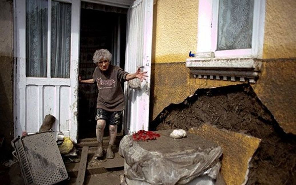 Румунія, Дорохов. Жінка дивиться на свій пошкоджений і затоплений будинок. Проливні дощі викликали потужні повені, в результаті яких у Румунії загинули більше 20 осіб, сотні людей були евакуйовані зі своїх будинків. / © AFP