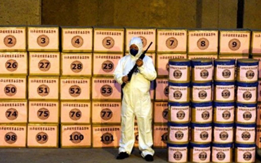 Тайвань, Тайпей. Озброєний співробітник бюро розслідувань охороняє конфісковані наркотики, перед тим, як іх спалять. Більше 1400 кг героїну, морфіну і марихуани було вилучено співробітниками бюро розслідувань у 2009 році. / © AFP