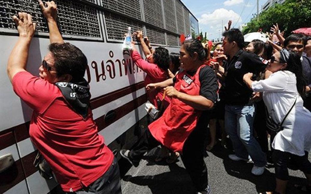 Таїланд, Бангкок. Члени антиурядового руху "Червоних сорочок" намагаються заблокувати автобус, на якому перевозять до в&#039;язниці лідерів опозиції, перед будівлею кримінального суду у Бангкоку. Тайський кримінальний суд відмовився випустити під заставу 11 лідерів "Червоних сорочок". Їм пред&#039;явлено обвинувачення у тероризмі через багатотижневі демонстрації у центрі Бангкоку. / © AFP
