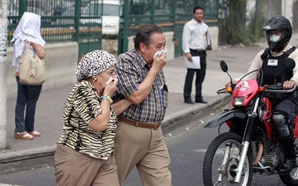 Місцеві мешканці виходять на вулицю, закриваючи обличчя масками. / © AFP