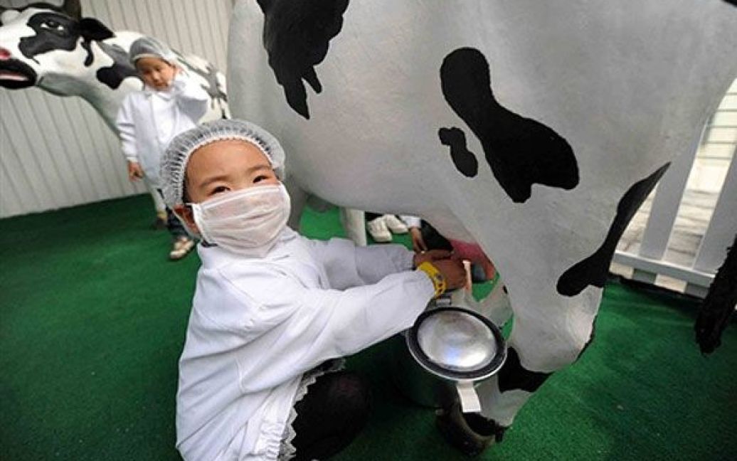 Китай, Шанхай. Діти вчаться доїти корів на Всесвітній виставці World Expo 2010 у Шанхаї. Сотні тисяч людей вже встигли відвідати найбільшу висnавку технічних досягнень у світі. / © AFP