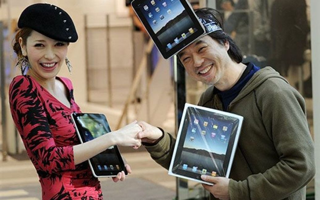 Японія, Токіо. Казукі Міура (праворуч) став першим клієнтом у магазині Apple, який придбав офіційний iPad у Японії. Щасливого покупця вітає модель, співачка і актриса Лена Фудзії. Компанія Apple почала продаж iPad у магазині японського інтернет-провайдера Softbank, який є ексклюзивним партнером Apple у Японії. Сьогодні iPad надійшов у продаж до низки країн: від Австралії і Японії до Європи. / © AFP