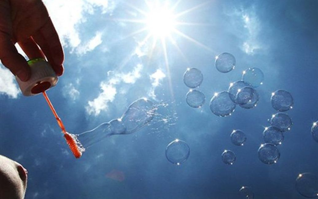 4.06. Хлопчик грається із мильними кульками у Гейдельберзі, Німеччина. Температура повітря у Німеччині сягнула 30 градусів Цельсія. / © AFP