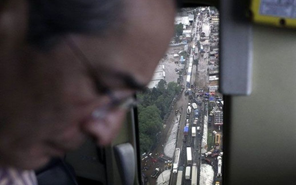 Президент Гватемали Альваро Колом летить над містом Палін, яке постраждало від стихії. / © AFP