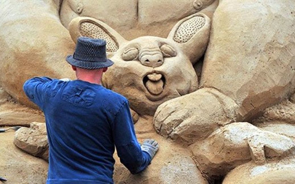 Німеччина, Берлін. Чоловік працює над піщаною скульптурою. У Берліні почався фестивалю "Sandsation", в якому беруть участь майстри піщаної скульптури з усього світу. Фестиваль триватиме на березі річки Шпрее до 29 серпня. / © AFP
