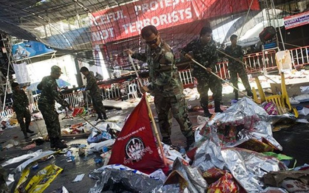 Таїланд, Бангкок. Тайські військові використовують червоні прапори антиурядових демонстрантів під час прибирання на головній сцені у розтрощеному таборі опозиціонерів. В центрі Бангкока тайські військові затримали бойовиків, які вчинили підпали у місті після того, як армія придушила антиурядові акції протесту. / © AFP