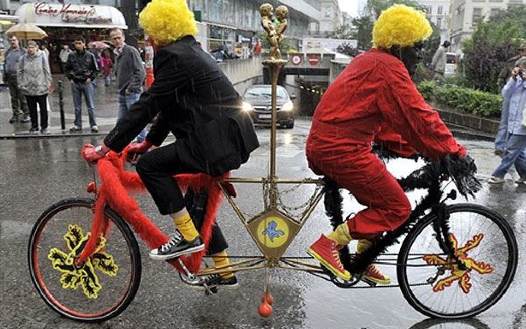 Бельгія, Брюссель. Учасники акції протесту, одягнені клоунами, сидять на "бельгійському велосипеді", який символізує опозиційні політичні партії в уряді Бельгії. У Брюсселі відбулась акція протесту проти забруднення, створюваного транспортними засобами. / © AFP