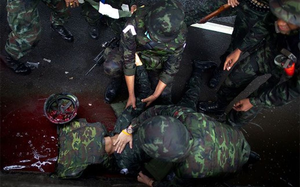 Таїланд, Бангкок. Військові намагаються надати допомогу постраждалому від "дружнього вогню" в ході зіткнення з демонстрантами під час антиурядових протестів. Близько 18 людей отримали поранення, коли війська відкрили вогонь по демонстрантах і застосували сльозоточивий газ. / © Getty Images/Fotobank