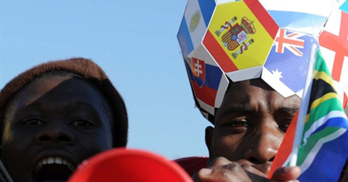 Південноафриканські вболівальники розважаються у Йоганнесбурзі. Коментатори, тренери та гравці неодноразово зверталися до ФІФА з прохання заборонити використання вувузел, на яких грають вболівальники, оскільки вони заважають сконцентруватися на полі. / © AFP