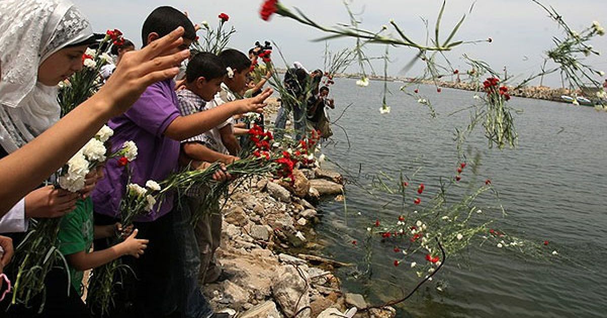 Сектор Газа. У місті Газа палестинські діти кидають квіти у море під час церемонії в пам'ять про активістів, загиблих під час інциденту між ізраїльськім спецназом і "Флотилією свободи". / © AFP