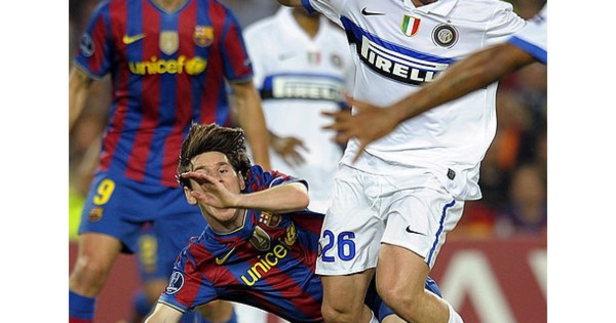 Лео Мессі ("Барселона") падає під час боротьби за м’яч з Чіву ("Інтер"). / © AFP