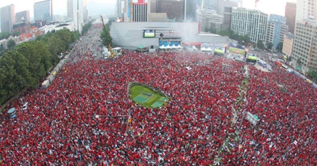 Десятки тисяч вболівальників Південної Кореї дивляться пряму трансляцію матчу ЧС-2010 проти збірної Нігерії на центральній площі Сеулу. За словами поліції, матч на площі дивилося щонайменше 260 тисяч людей. / © AFP