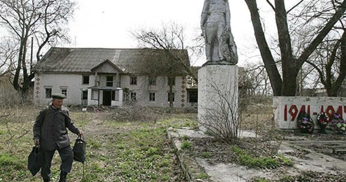 Білорусь, село Тулговичі, 30-км зона. Чоловік йде повз пам’ятник захисникам Вітчизни. / © AFP