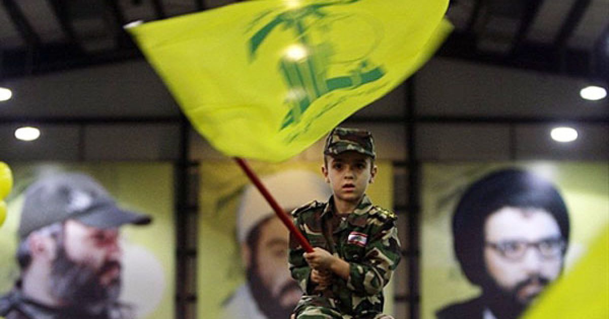 Ліван, Бейрут. Ліванський хлопчик у військовій формі розмахує прапором руху "Хізбалла" під час церемонії, присвяченої 10-й річниці виведення ізраїльських військ з південного Лівану. Лідер "Хізбалли" Хасан Насралла заявив, що його бойовики здатні знищити військово-морський флот Ізраїлю і будь-які інші кораблі, які прибудуть до Ізраїлю у випадку нової війни. / © AFP