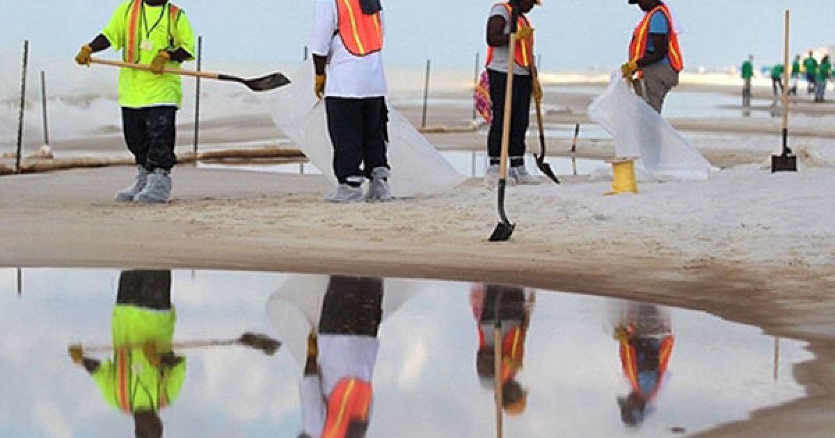 США, пляж Orange Beach. Працівники збирають мазут і нафту на березі Орандж Біч, штат Алабама. Мільйони галонів нафти вилилося у Мексиканську затоку після вибуху, який стався на буровій платформі 20 квітня. / © AFP