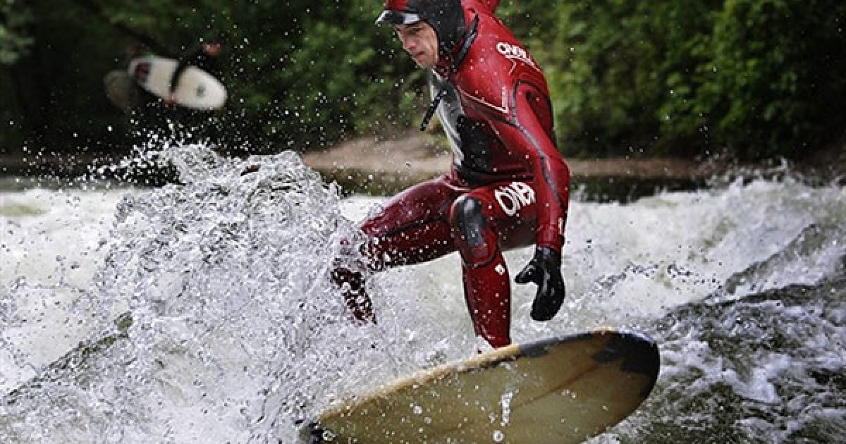 Німеччина, Мюнхен. Серфер катається на хвилі на річці Ізар у Мюнхені. Завдяки сильним хвилям річка є популярним місцем для серфінгу.