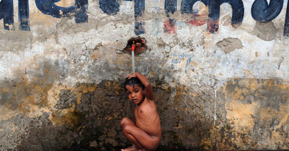 Індія, Аллахабад. Дитина прохолоджується поруч зі стіною, на якій написано: "Змивайте у Гангу ваші гріхи, а не вашу вину або бруд". Північні індійські штати потерпають від спеки, більше 20 людей загинуло через високі температури.