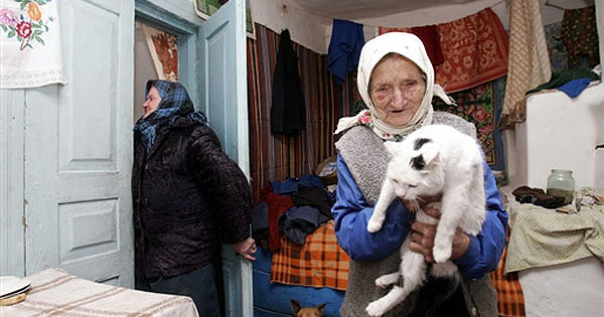 Україна, село Ільїнці, 30-км зона, 2006 рік. Зіна Гузенко, 93 роки, тримає свого кота. / © AFP